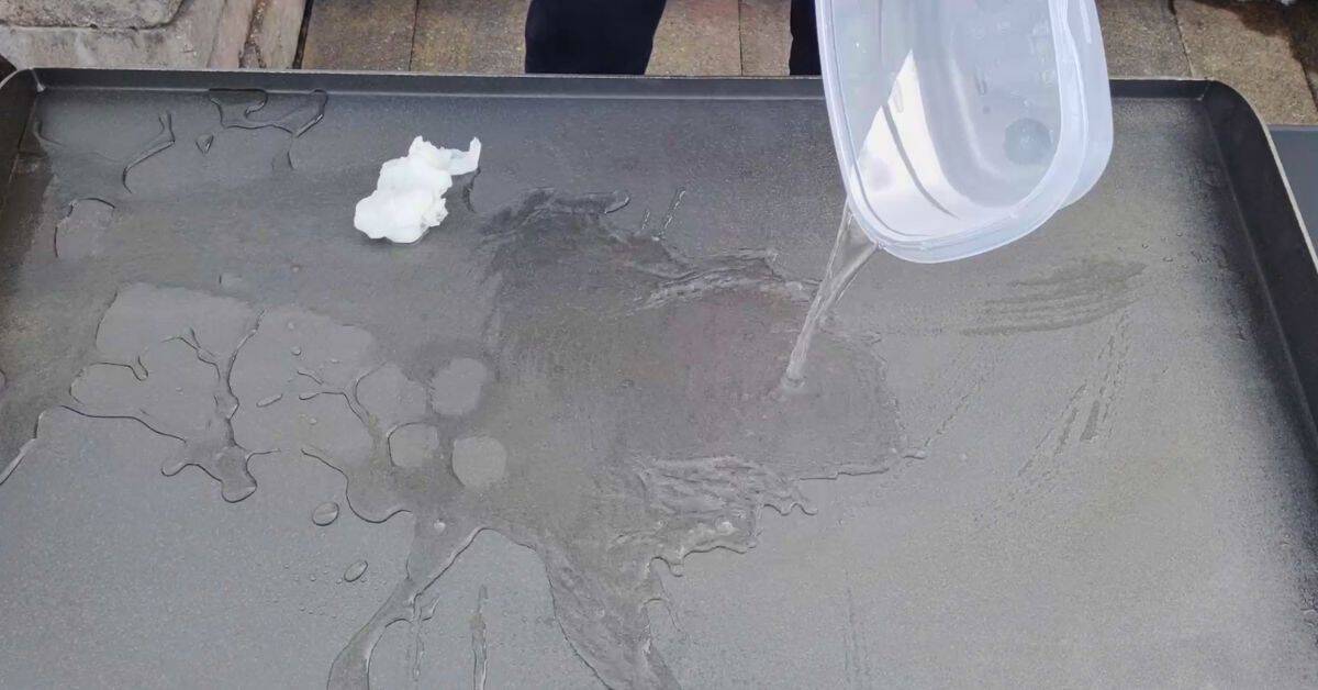 water being poure on a blackstone griddle next to a paper towel.