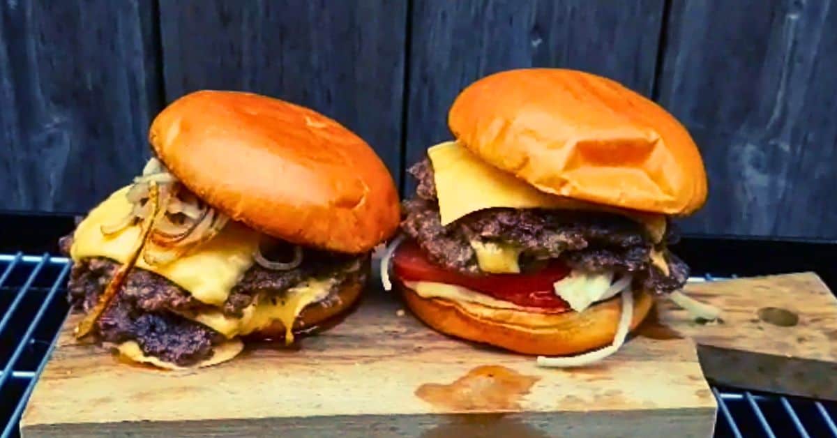 Two smash burgers on a wooden board. 