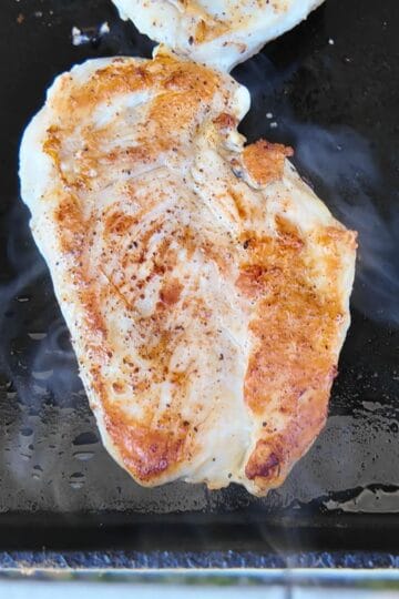 chicken breast golden brown on a griddle