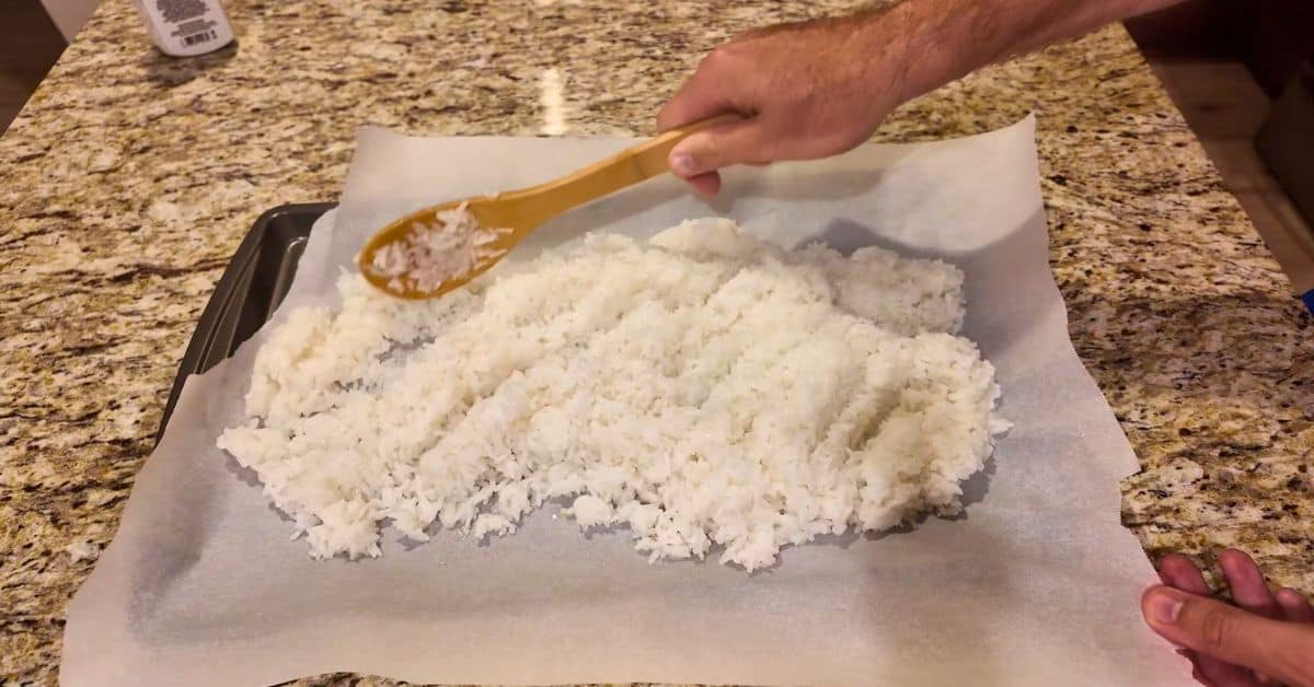 cooked jasmine rice on a cookie sheet with parchment papper.  Spread out with a wooden spoon.