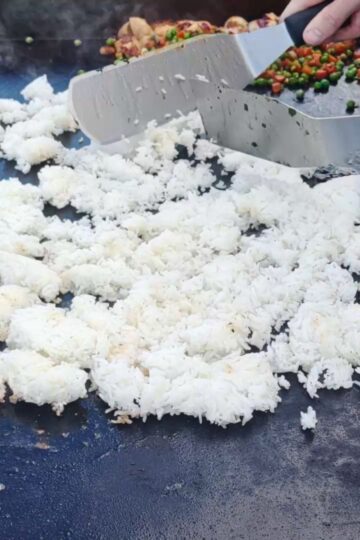 White Rice on a blackstone griddle with 2 spatulas