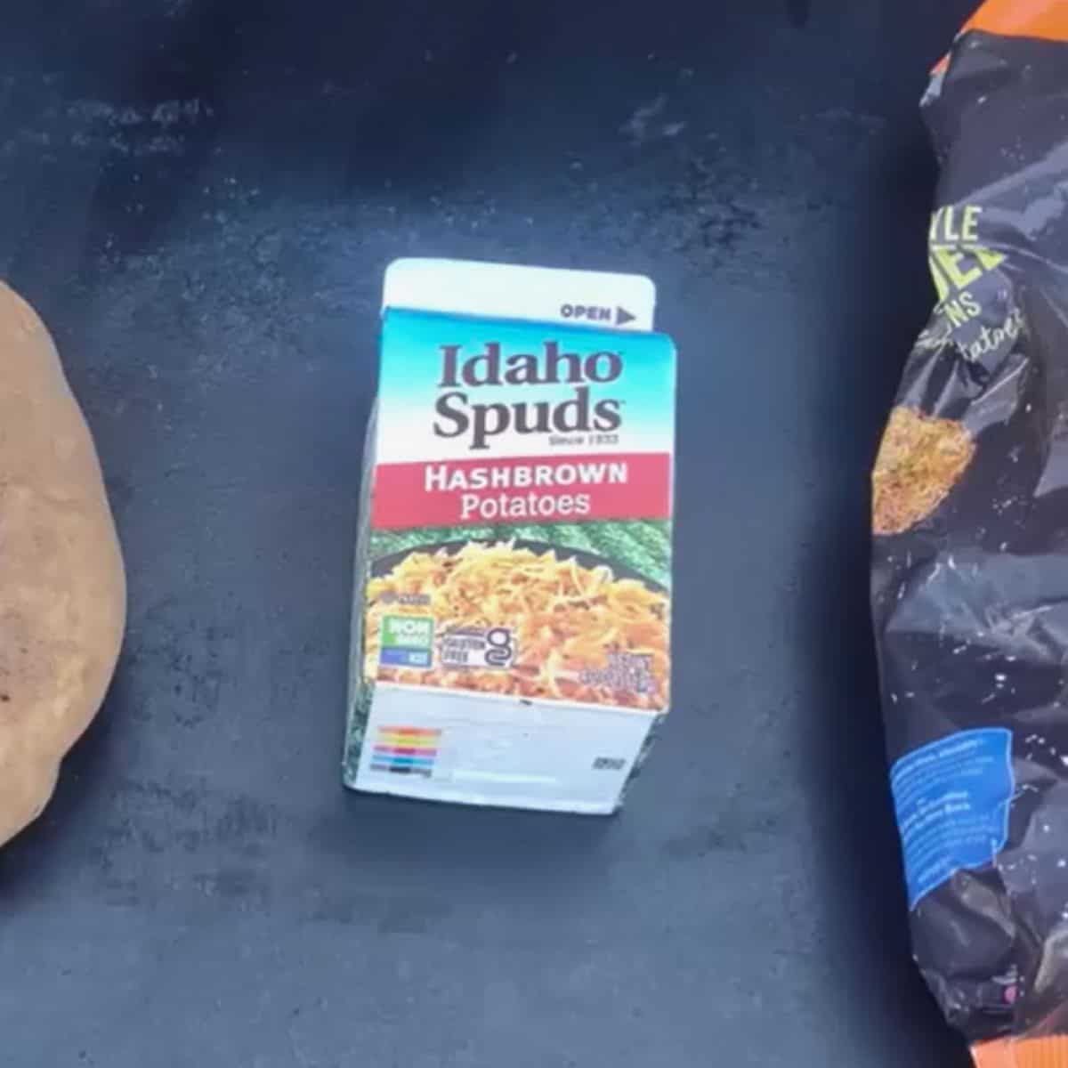 A box of shredded dehydrated hash brown potatoes on a griddle