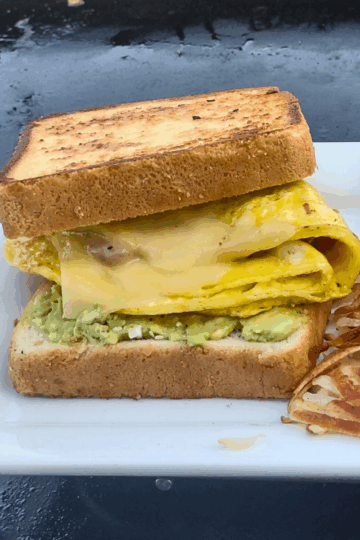 A hearty sandwich of egg cheese, bacon and avocado on griddled texas toast