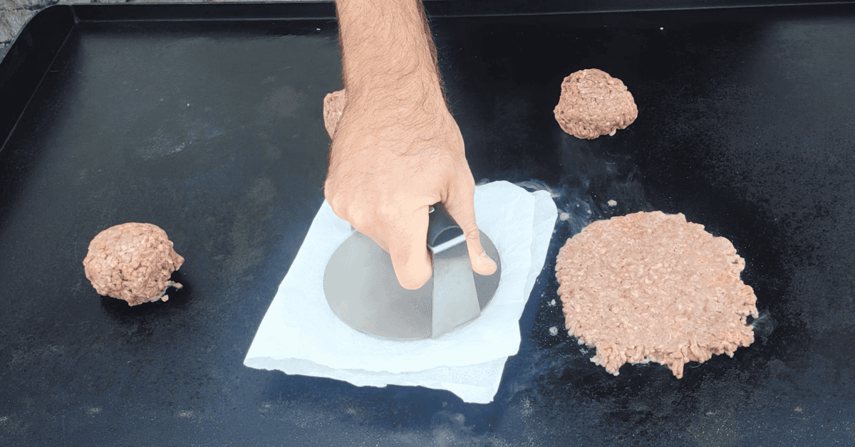 I smash burger press with smashed burgers on a blackstone griddle.