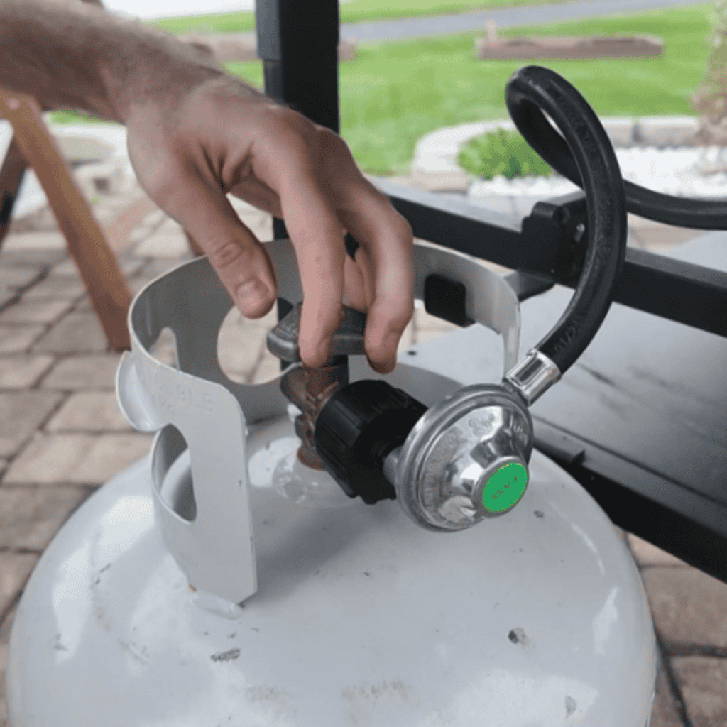 screwing in a hose on a propane tank.