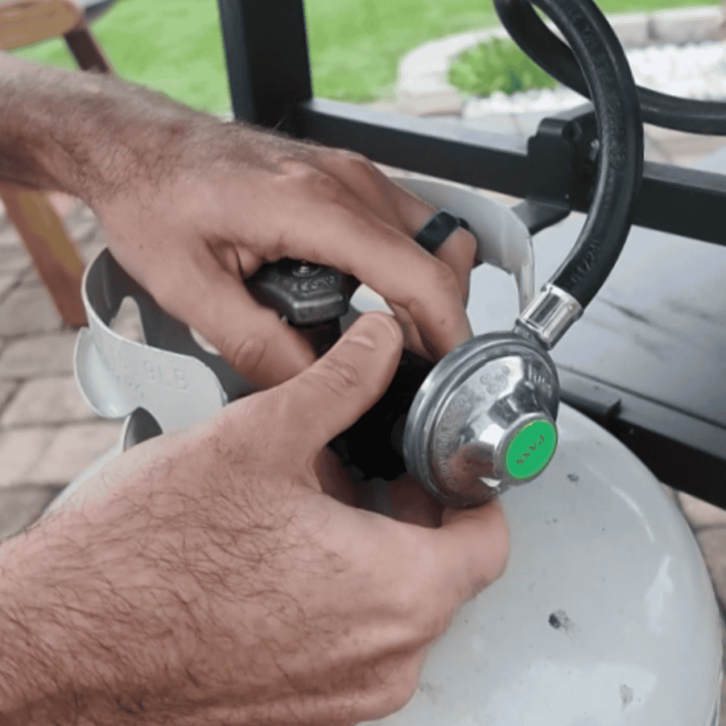unhooking a propane tank on a blackstone griddle.