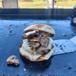 a mushroom swiss burger on a griddle